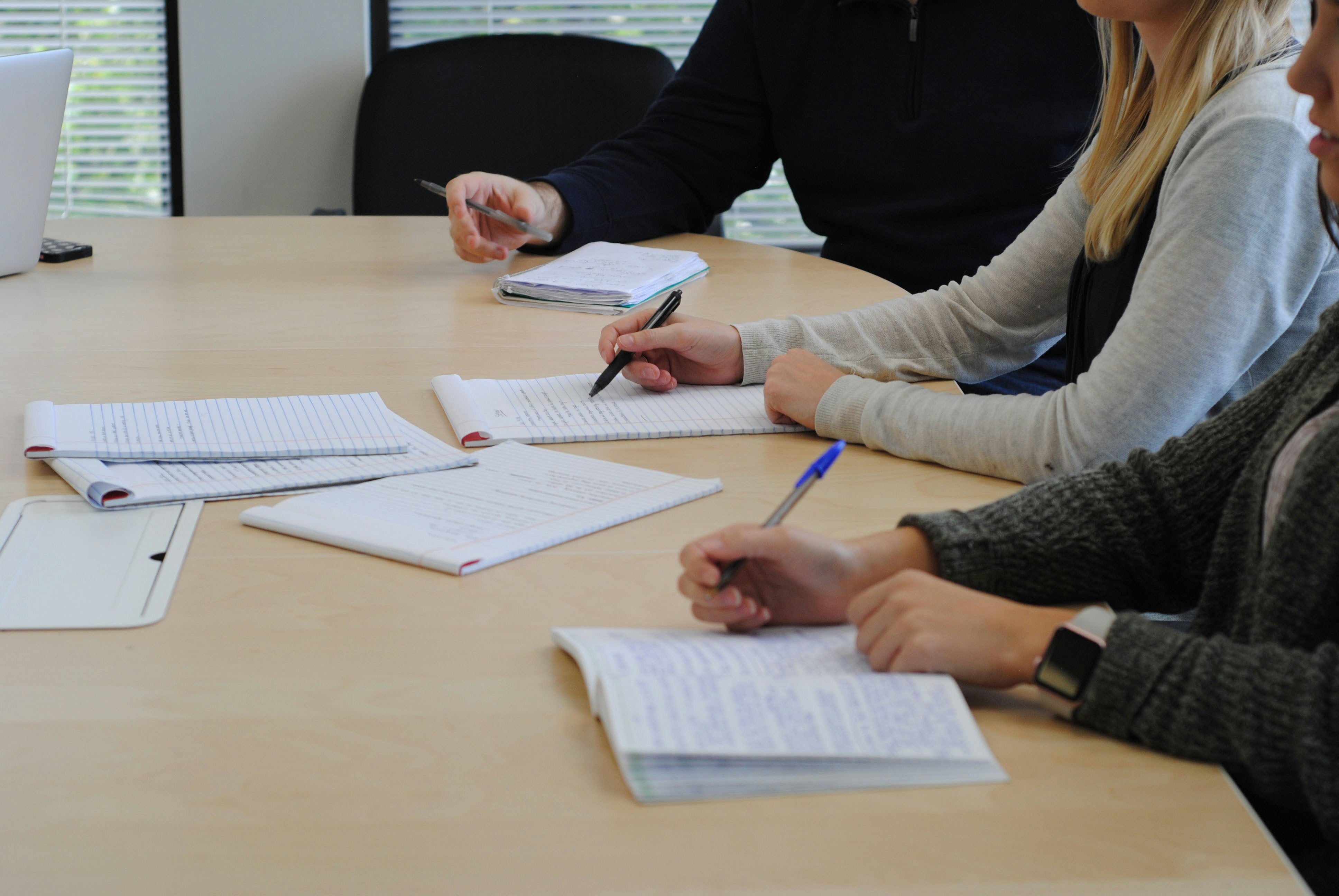 Two project professionals reviewing separate documents at a capital project planning table